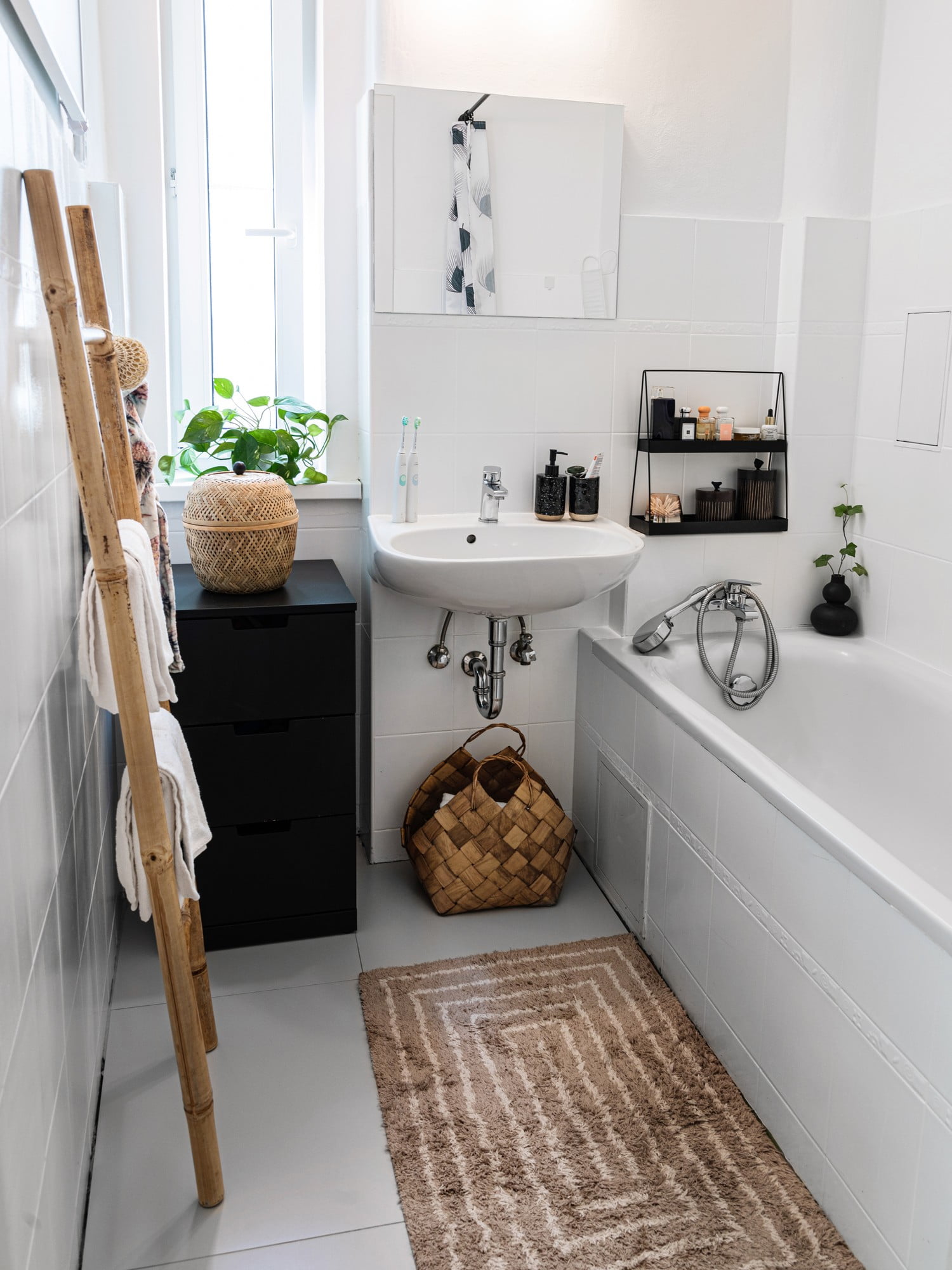 I materiali naturali rendono più confortevole il bagno in bianco e nero.